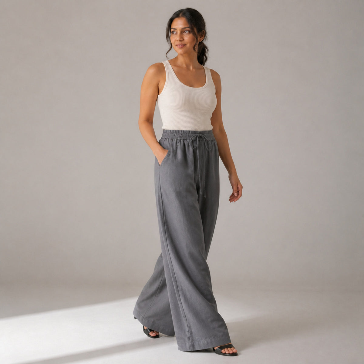 Billie Linen Trousers in grey, three-quarter view showing the wide leg in movement
