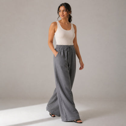 Billie Linen Trousers in grey, three-quarter view showing the wide leg in movement