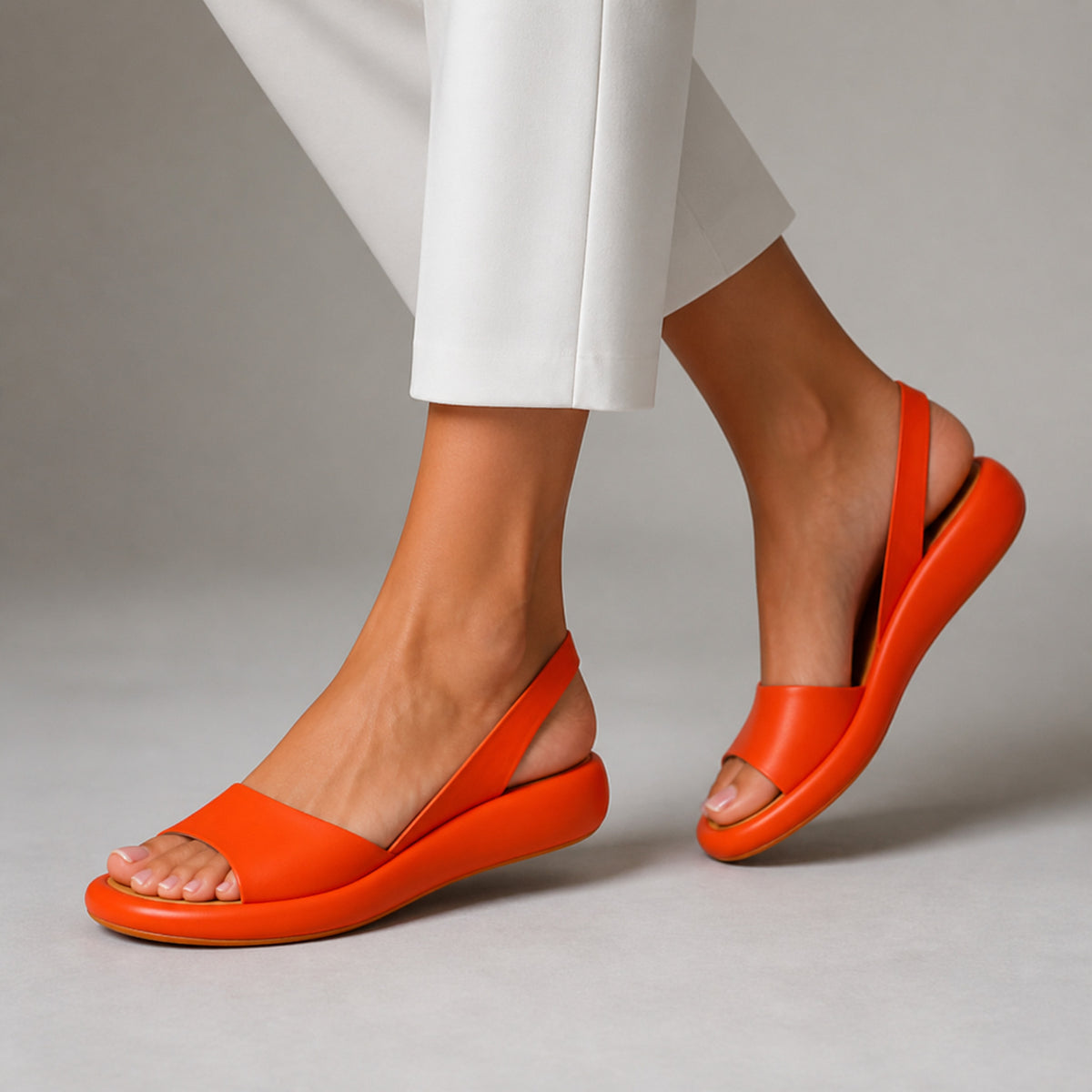 Zarina Slingback Sandals in orange, worn mid-step